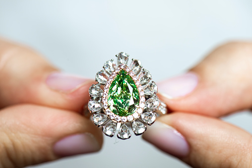 Hands showing diamond. Emerald.