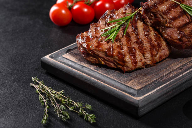 istock Fresh juicy delicious beef steak on a dark background 1301966158