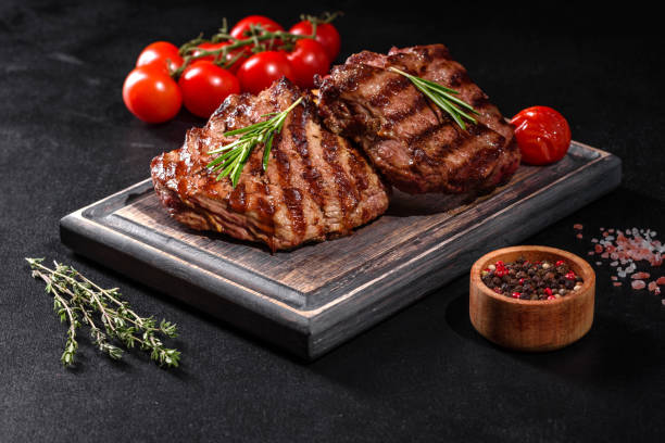 istock Fresh juicy delicious beef steak on a dark background 1301966159