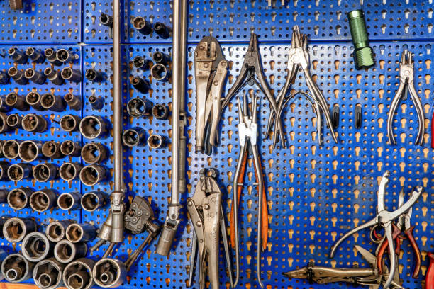istock A SERIES OF MECHANICAL TOOLS INCLUDING VARIOUS PLIERS, SOCKET WRENCHES, SCISSORS AND EXTRACTORS. THE ALL HANGED FROM THE BLUE BACKGROUND. PERFECT SHOE FOR ARTS, TRADES AND WORKS. 1301966314