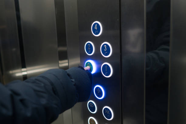 istock Boy pressing button of lobby in elevator. 1301969575