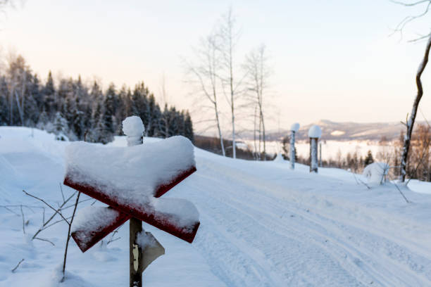 istock Sign marking a snowmobile trail in foreground and landscape in background. 1301972114