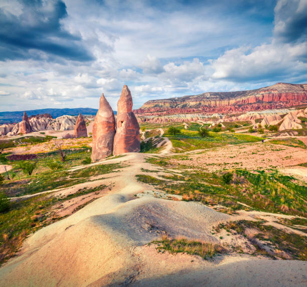 impressionante cena de primavera da capadócia. vista matinal pitoresca do vale da rosa vermelha em abril. aldeia cavusin localizada, distrito de nevsehir, turquia, ásia. histórico de conceito de viagem. - goreme rural scene sandstone color image - fotografias e filmes do acervo