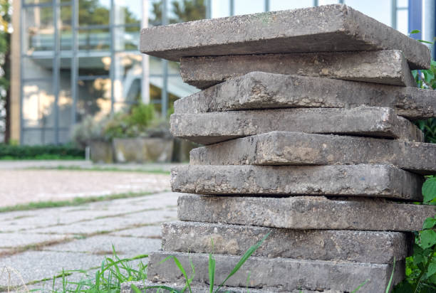 istock Concept Construction site and redevelopment: paving stones or concrete slabs stacked on top of one another on a neglected property in front of a modern building 1301973161