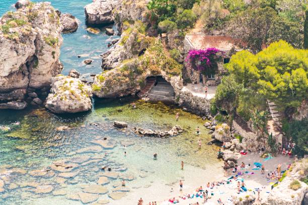 Oasis in Sicily High angle view of Isola Bella Nature Reserve surrounded by people swimming  the crystal clear water. True paradise on Earth isola bella taormina stock pictures, royalty-free photos & images