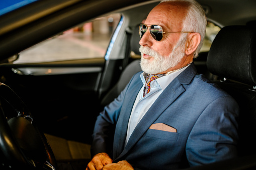 Photo of a senior businessman driving a car