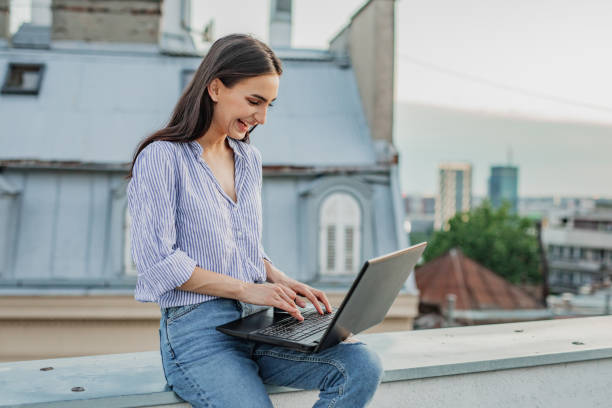 istock Young woman working on a laptop on the terrace 1301977993