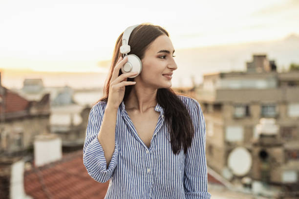 istock Young woman enjoying on the rooftop and using mobile phone 1301978081