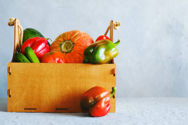 istock Wooden crate full of  fresh vegetables on gray background. 1301980310