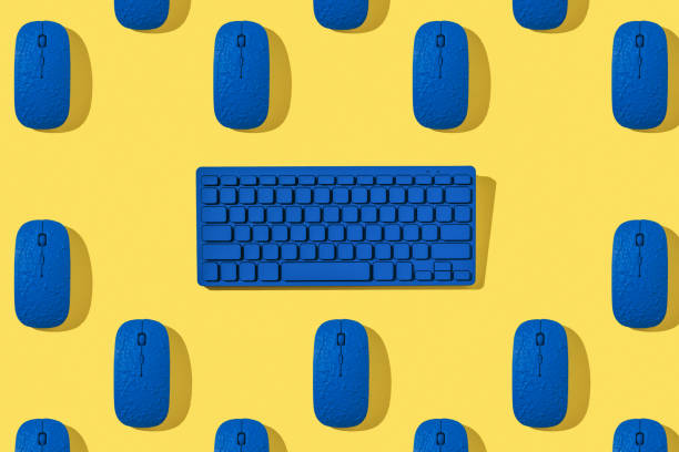 istock A pattern of blue computer mice and a keyboard on a yellow background. 1301982547