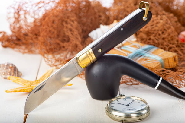 Vintage still life about fishing with a pipe and a sailor knife