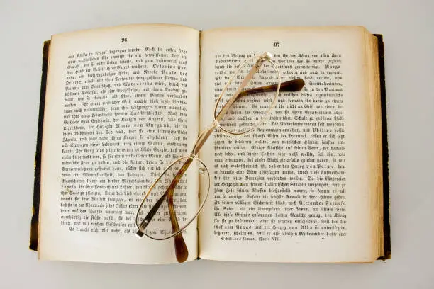 Reading glasses on an old book edition of Schiller`s works