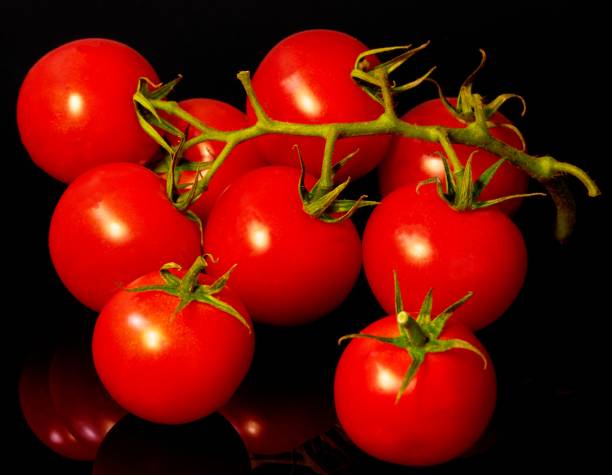 istock red tomatoes lie on a black background 1301985699