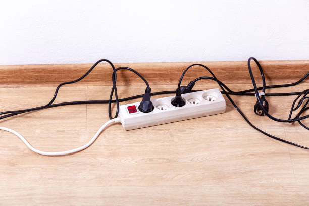 istock Plug strip with a red on off switch on the floor, white power extension cord plugs connected to it, tangled black wires, european plugs, empty room. Closeup, copy space. Electricity usage concept 1301986479