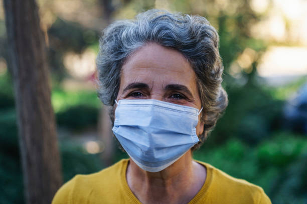 istock Senior woman wearing a protective mask and smiling 1301991931