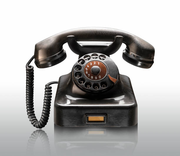 Retro style home phone from the late 19th century, made of wood and metal, on a tabletop upholstered in velvet. Stationary, rotary dial, analog mode of operation.