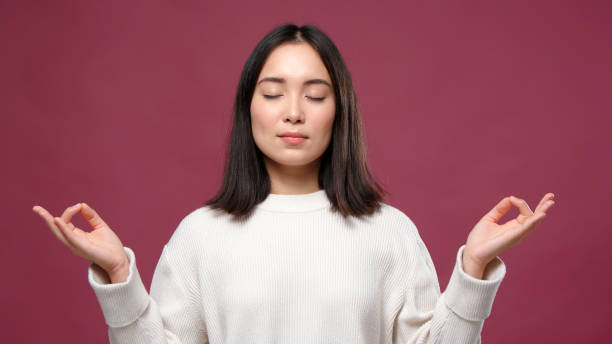 istock Young asian woman meditate against marsala copyspace 1301995557