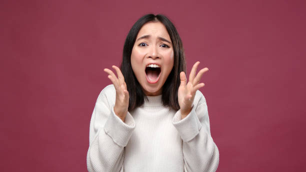 istock Young asian woman scream shocked against marsala copyspace 1301995679