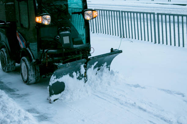 Snowplow removing snow on street after blizzard. Snowplow vehicle clears snowy road during blizzard. Snow clearing equipment. Tractor with snow plow blade clears road in city from fresh fallen snow. quita nieve en la calle después de la ventisca. el vehículo quitanieves despeja la carretera nevada durante la ventisca. equipos de limpieza de nieve. tractor con hoja de arado de nieve despeja la carretera en la ciudad de nieve caída fresca.