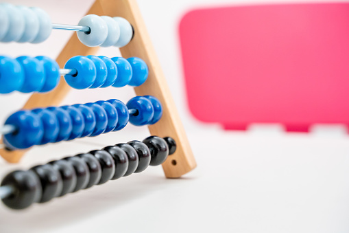 Colorful Abacus Close Up on White and Pink Background with Copy Space, Concept of Finances and Business. Arithmetical and Mathematical Learning Toy