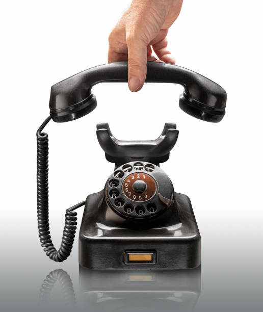 istock Hand picking up black classic rotary phone 1950 on white background 1302000745