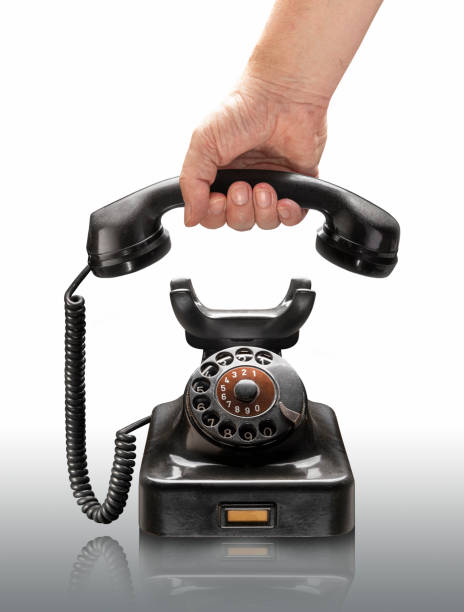 istock Hand picking up black classic rotary phone 1950 on white background 1302000813