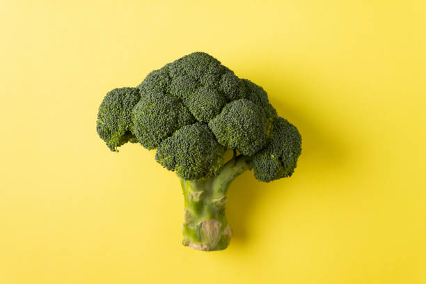 istock Broccoli on a yellow background. Horizontal orientation. View from above. 1302004060