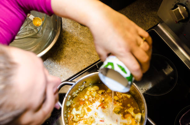 istock Woman pouring coconut milk in pan 1302004818