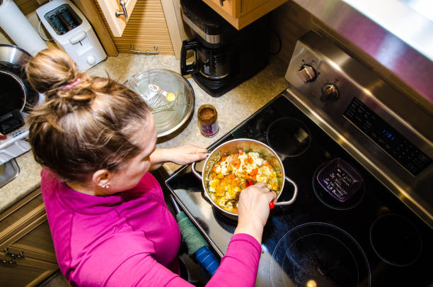 istock Woman mixing vegetables in pan 1302004833