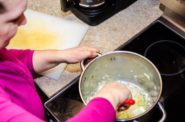 istock Woman mixing onions in pan 1302004871