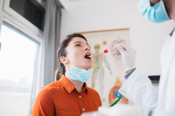 istock Doctor taking a swab from a patient 1302006815