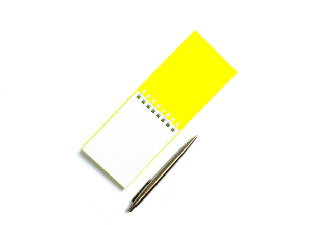 istock yellow cover notepad with metal pen isolated on white background 1302007429