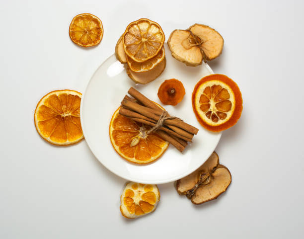 istock dried orange and cinnamon slices on a white plate. white table background. holiday concept, table decoration, meeting new year and christmas. 1302007569