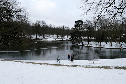People walk and enjoy the snow-covered  Bois de la Cambre park  in Brussels, Belgium on February 10th, 2021.