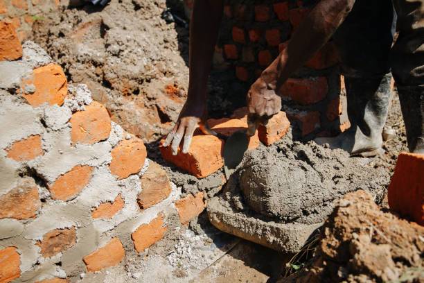 istock Man building a brick wall in Uganda, Africa 1302008738