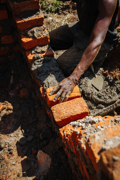 istock Man building a brick wall in Uganda, Africa 1302008759