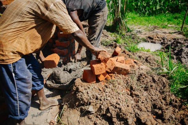 istock Man building a brick wall in Uganda, Africa 1302008828