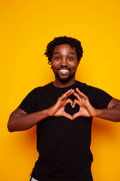 istock young handsome african american guy student posing cheerful and gesturing on yellow background, lifestyle people concept 1302015130
