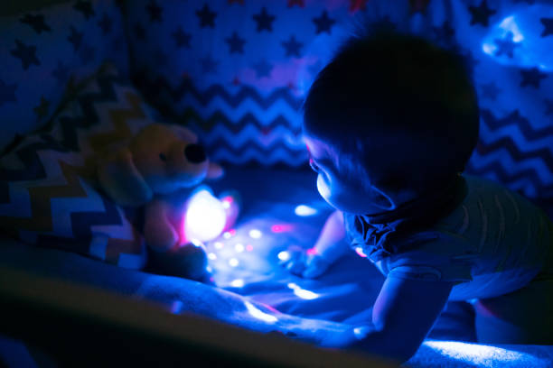 istock Baby boy playing with a luminous toy in his crib 1302017298