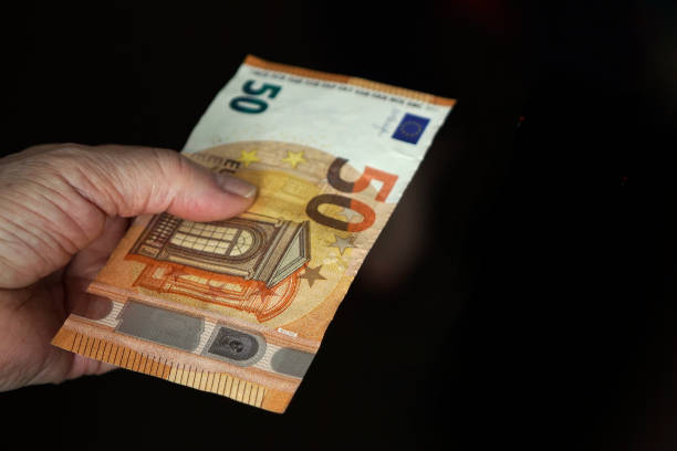 istock few bills in his hand on a dark background. Copyspace. 1302017644