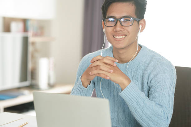 istock asian young student man entrepreneur wear earphones working with computer studying learning online at home. e-learning webinar meeting. social distance in covid pandemic 1302017771