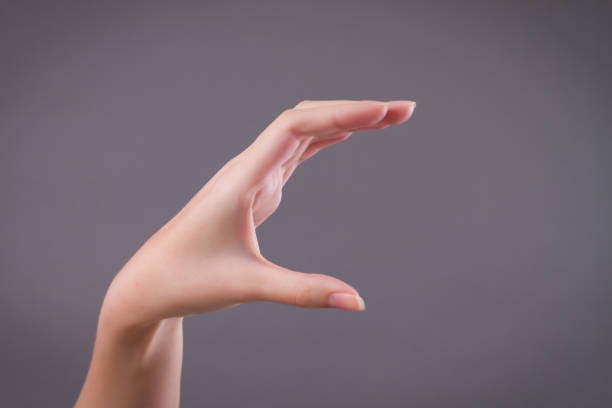 istock woman hand holding, catching, picking something 1302018490