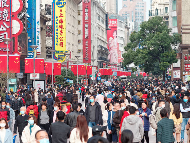 Crowded people walking on Shanghai Nanjing road in Spring Festival, almost everyone wearing face mask due to pandemic of coronavirus. stock photo
