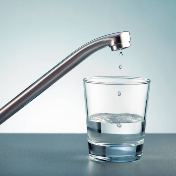 ガラスに水を一滴入れ、水、蛇口、水栓を節約します。 - faucet glass water running water ストックフォトと画像