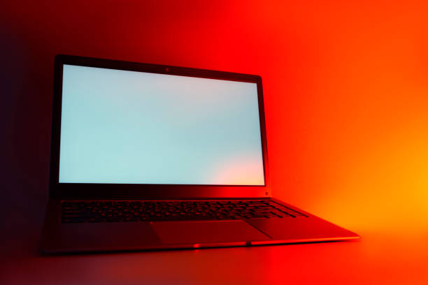 Slim modern laptop with white screen Mockup set against bright, red creative light.
