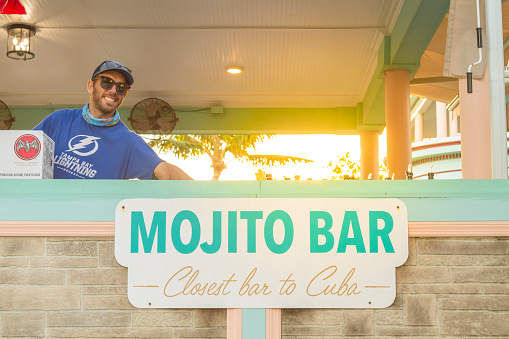 Key West, Florida, USA - December 30, 2020: A bar employee take a second for smiling to the picture at 
