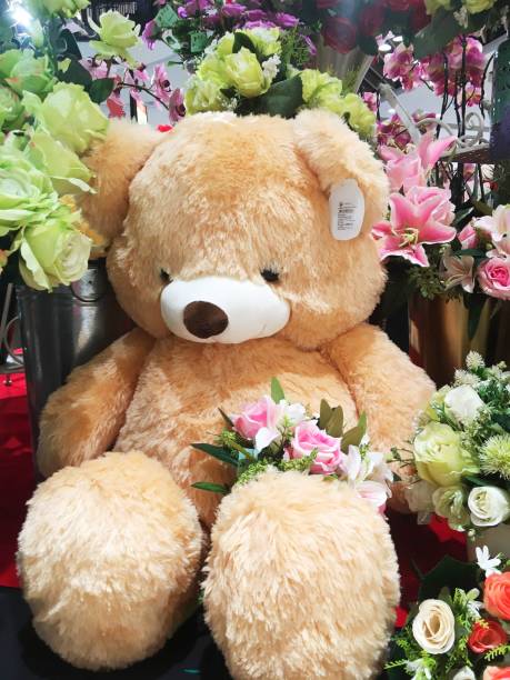 istock a teddy bear with flowers on the counter in the store. 1302044016