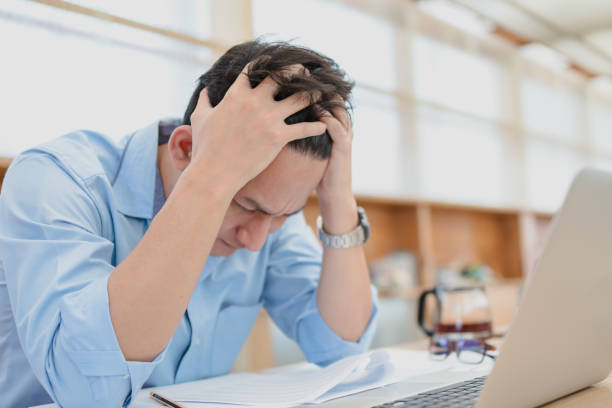 istock Tired businessman at workplace in office holding his headache or angry. Overworking, making mistake, stress, termination, fail, bad, sad tired or depression concept 1302047608