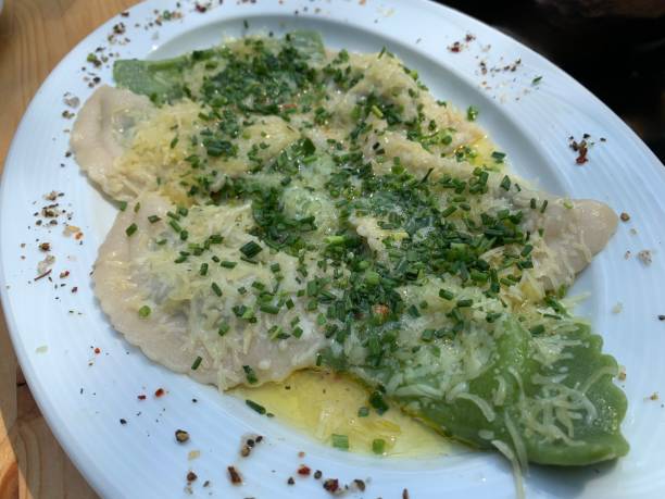 best dinner lunch and brunch homemade or in traditional or exclusive restaurant tyrolean schlutzkrapfen schlutzer ravioli de la pasta de espinacas pasta parmesano derretido mantequilla y cincel sal y pimienta servido en una sartén de hierro en una cabaña de montaña en tirolesa cerca de schwaz e innsbruck y el karwendel en los alpes