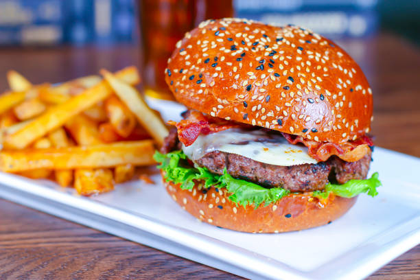 istock A Cheese, Bacon hamburger with french fries on a white plate. 1302050104